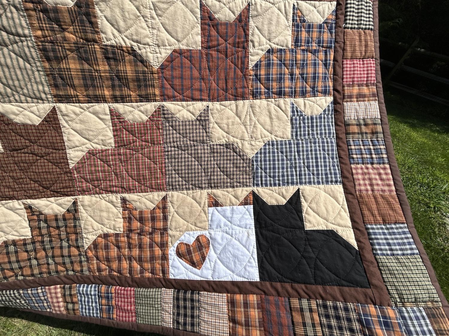 A closeup of the bottom right corner, where there are two outlier cats. The one on the left is a white cat with orange ears and an orange heart on its flank. The one on the right is a black cat. They're snuggling face-to-face.