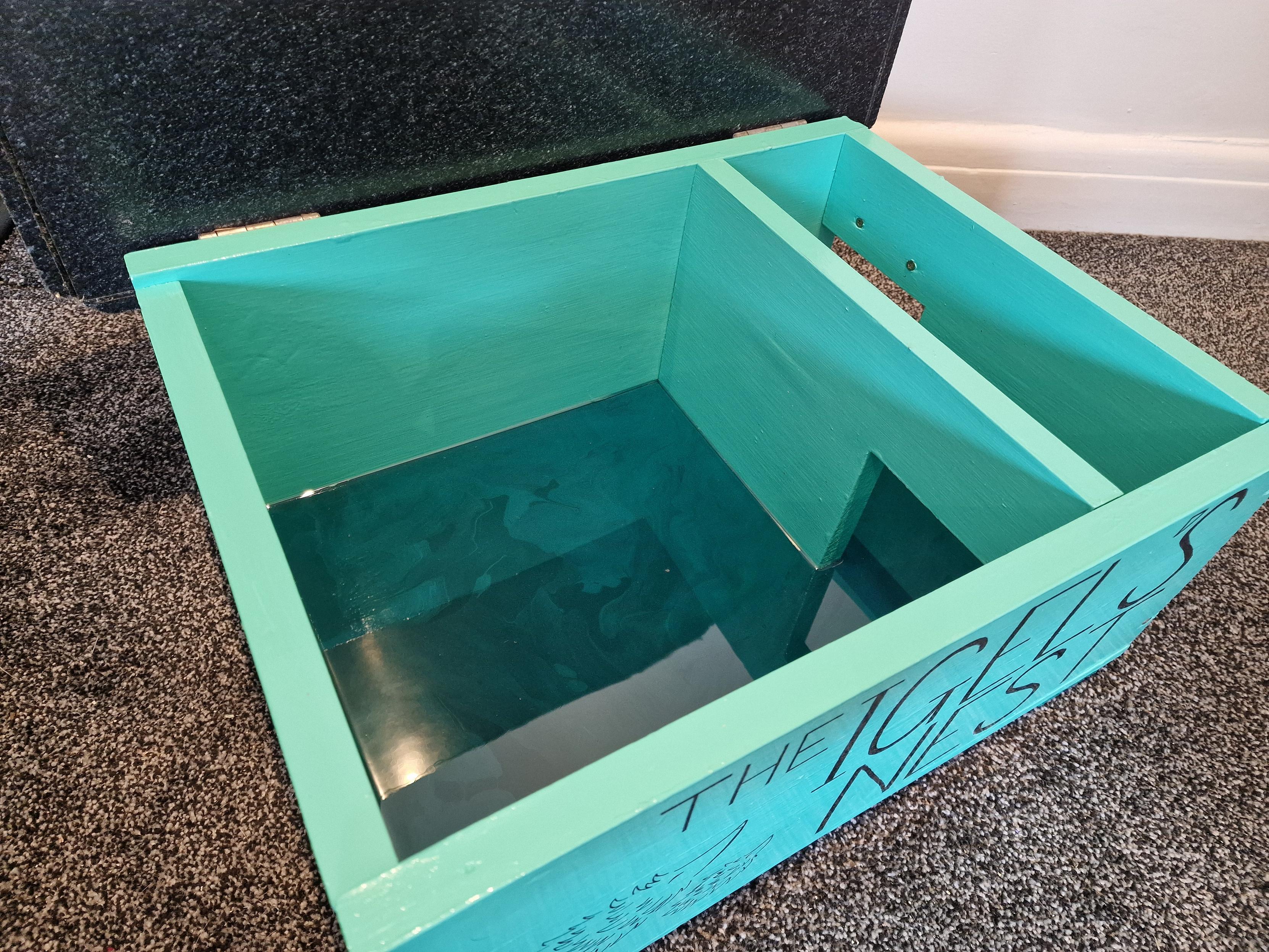 Turquoise hedgehog nesting box with a glossy dark green floor inside