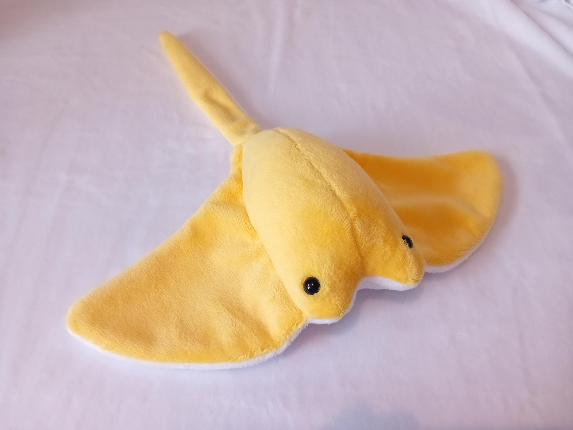 A lovely yellow stingray plushie with a white underbelly.