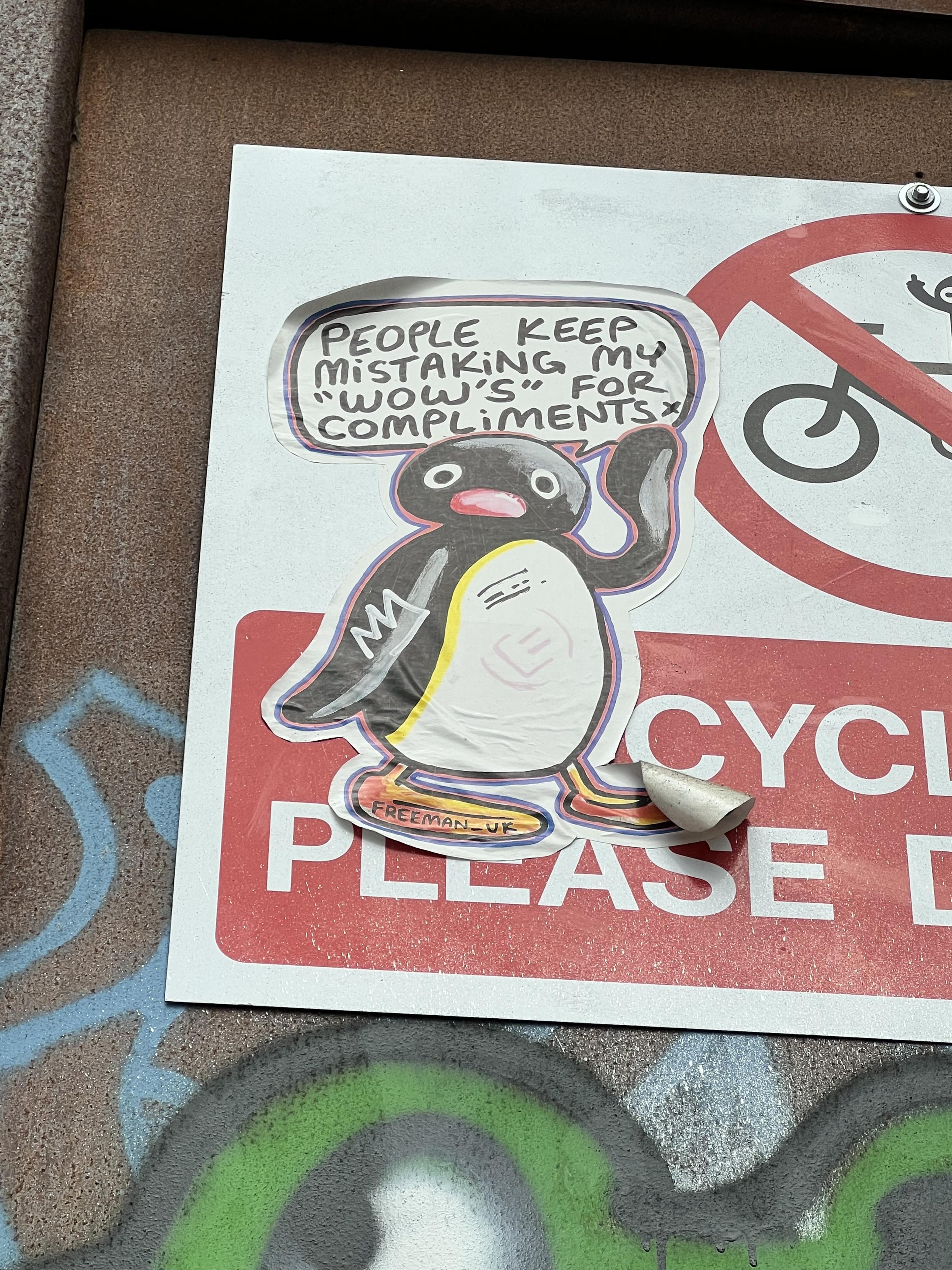 big sticker of Pingu stuck on a “cyclists please dismount” sign somewhere in London. he’s waving and he has a speech bubble that says “people keep mistaking my “wow’s” for compliments”. this isn’t typical of him