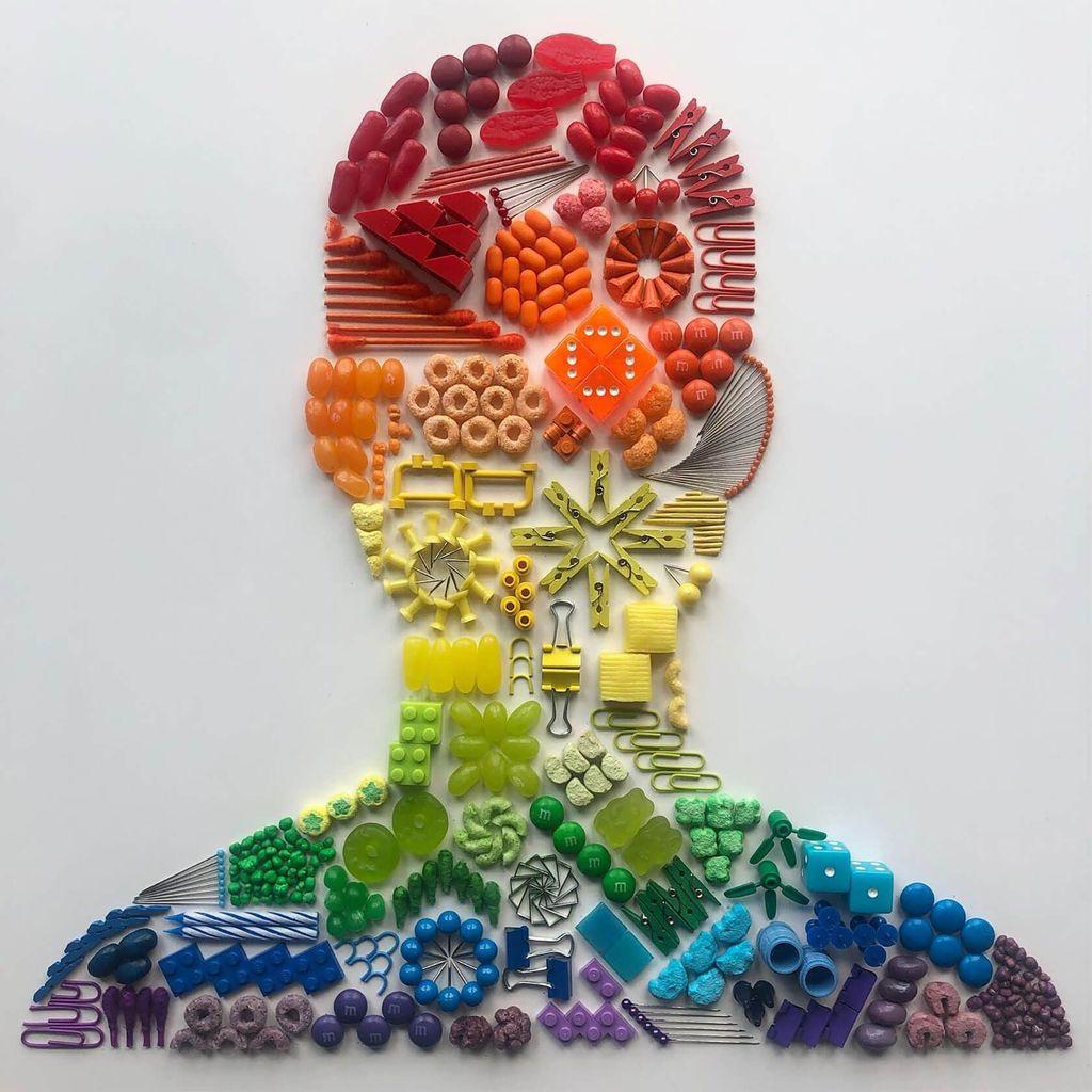 Human head silhouette filled with colorful small objects arranged by color gradient on a white background.