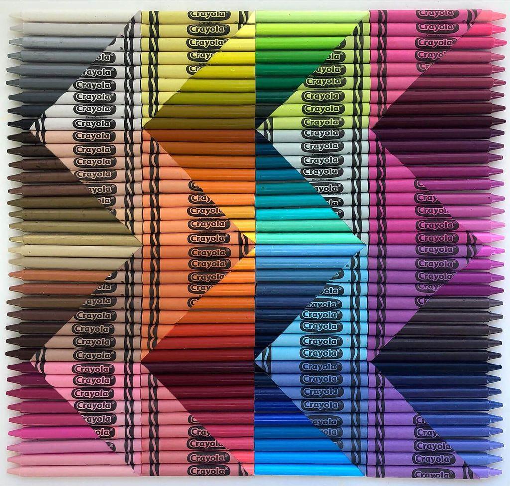 A colorful geometric pattern made by aligning Crayola colored pencils in rows, arranged to form diamond shapes.