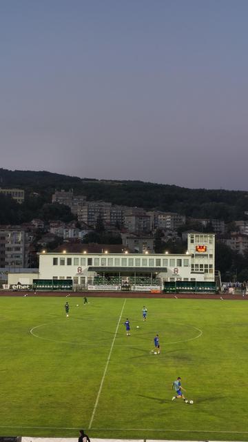 Football stadium. People on the pitch.  as a background buildings