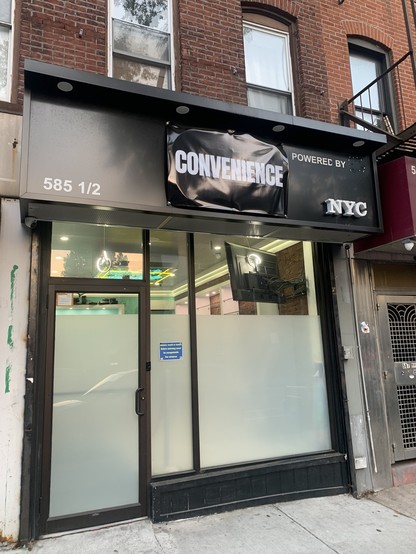 frosted glass store front with new sign hanging on awning reading CONVENIENCE