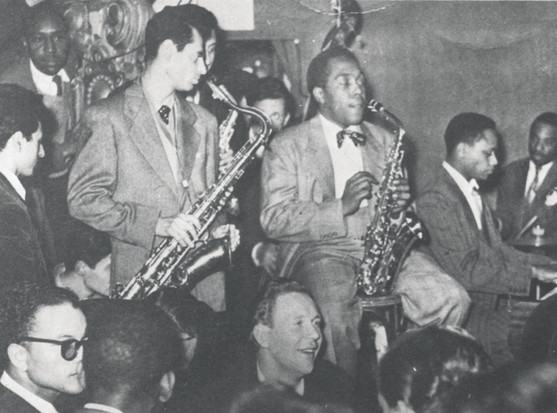 Charlie Parker & other jazz musicians onstage, crowd members visible