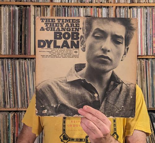your DJ with The Times They Are A-Changin' LP in front of face