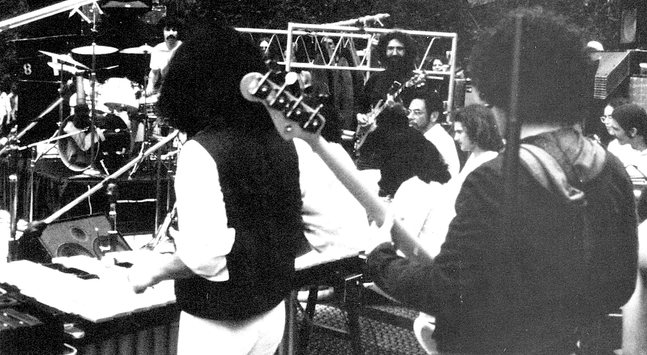 the crowded stage at Golden Gate Park, Jerry Garcia amid many percussionists