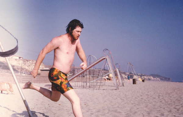 topless Brian Wilson on the beach, running towards the surf