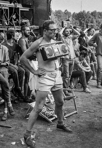 man with boombox around his neck at music festival