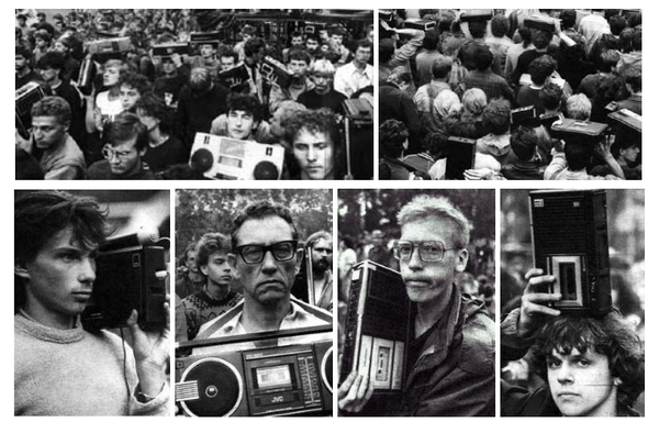men hold up portable tape machines at music festival