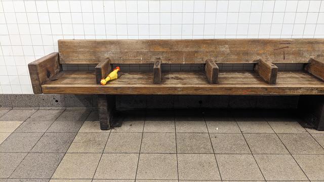 toy chicken on empty subway bench