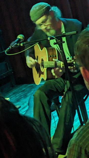 Richard Bishop plays acoustic guitar