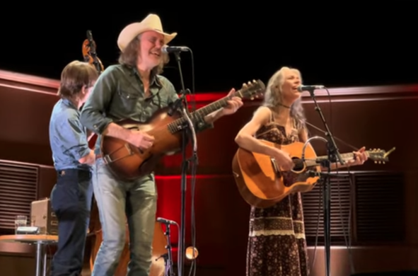 David Rawlings and Gillian Welch sing and play acoustic guitars, Paul Kowert (obscured) playing upright bass