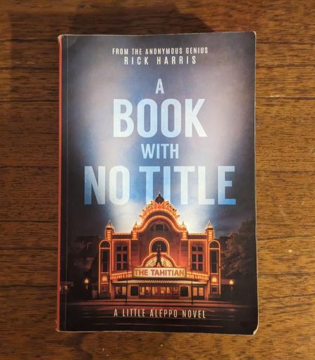 a book titled "A Book With No Title: A Little Aleppo Novel" with illustration of movie palace called the Tahitian