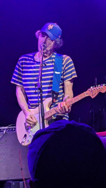 Ira Kaplan plays guitar, wearing Mets hat