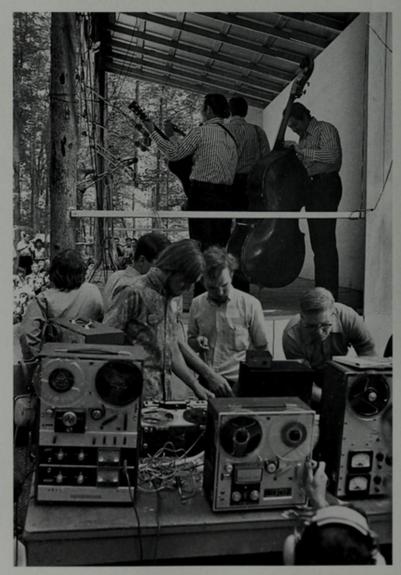 people operate tape machines sidestage at bluegrass festival