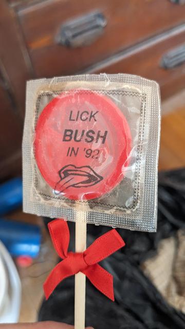 condom as lollipop with wrapper that reads "Lick Bush in '92."