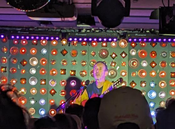 a man plays guitar with resting wistful face