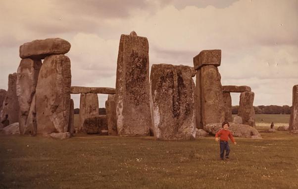 small child looking happy in front of Stonehenge