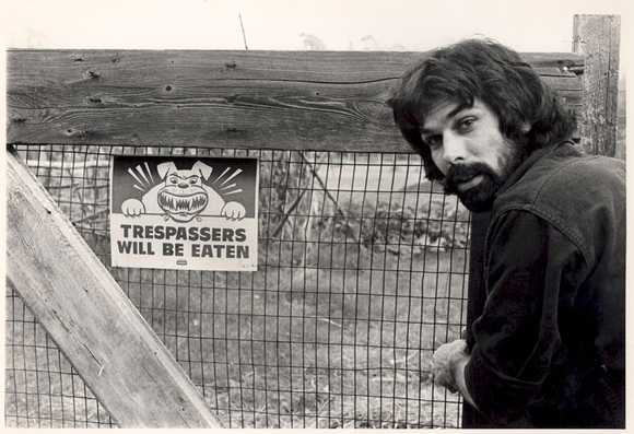 Mickey Hart next to fence with sign reading "Trespassers will be eaten"