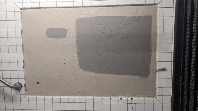 an ad with graffiti covered over by gray blobs