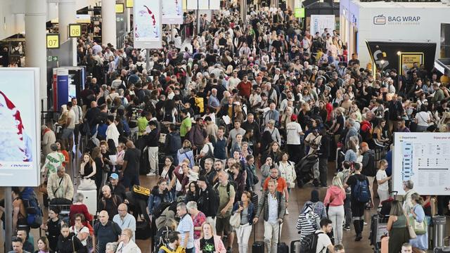 People walk by a departures board after a cyber attack caused delays at Brussels International Airport in Zaventem, Belgium, Saturday, Sept. 20, 2025. (AP Photo/Harry Nakos)