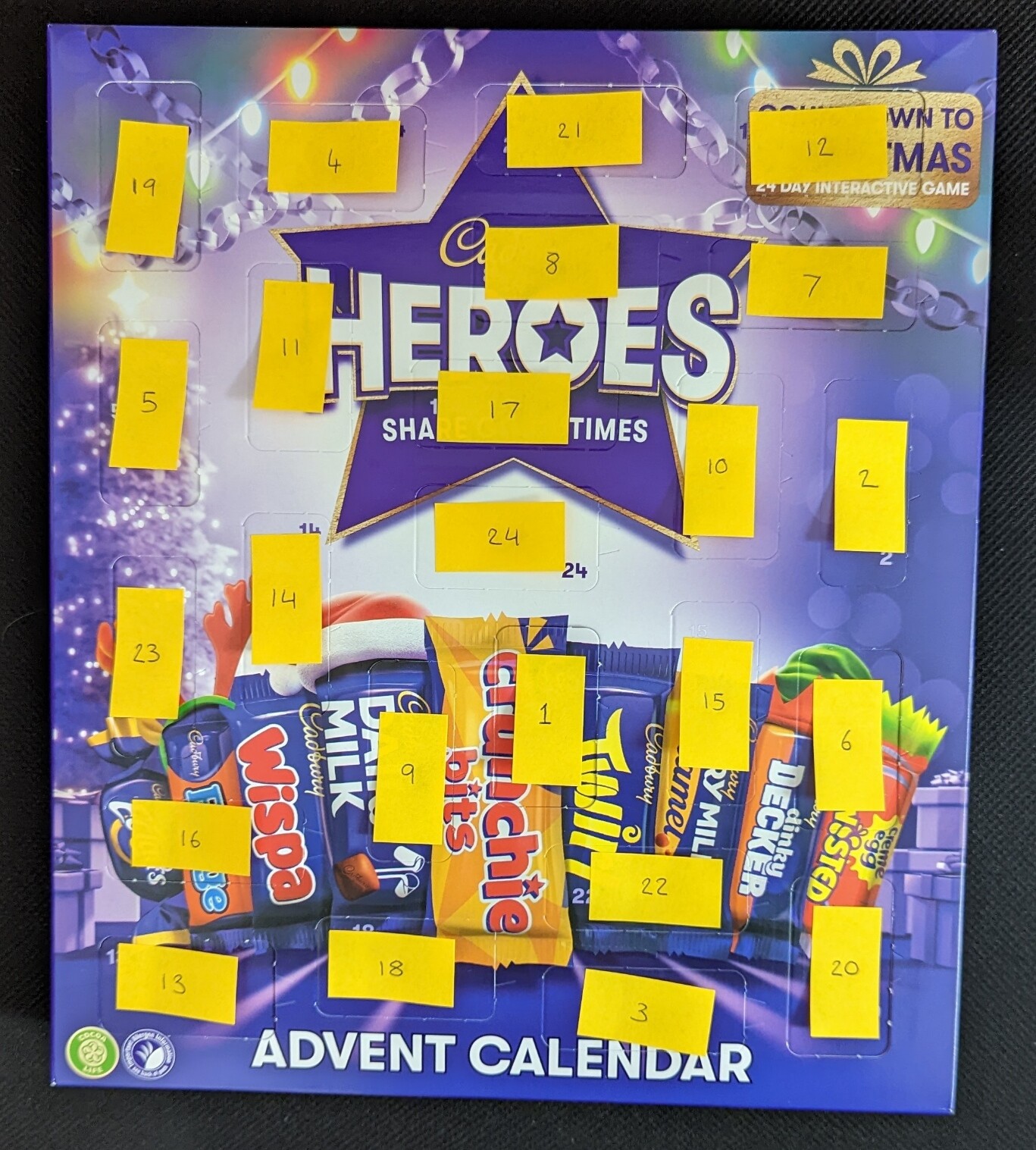 Modified Cabury's Heroes Advent Calendar 2022. This one has yellow sticky notes that are numbered 1-24 and are placed over the corresponding doors of the advent calendar.