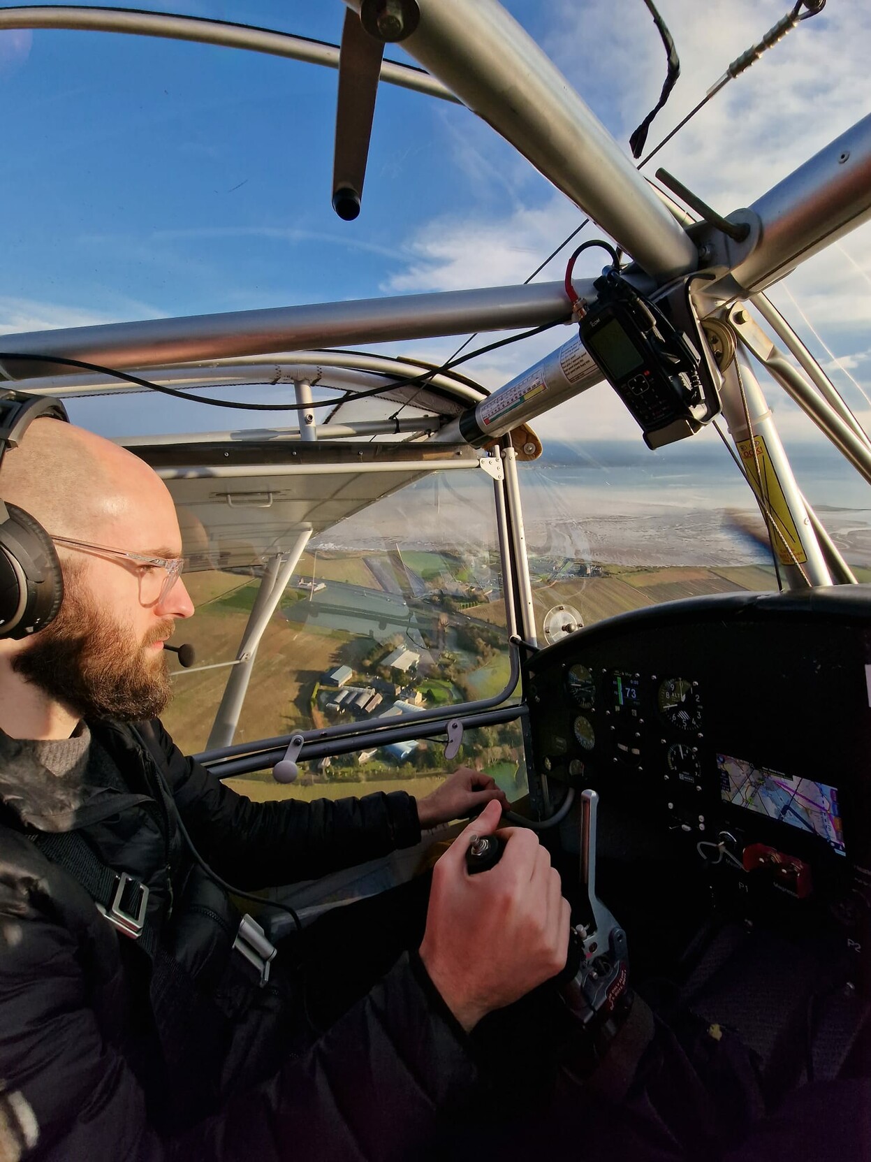 Me flying a light aircraft. The photo is take from the passenger seat. You can see some building and the coast line below us.