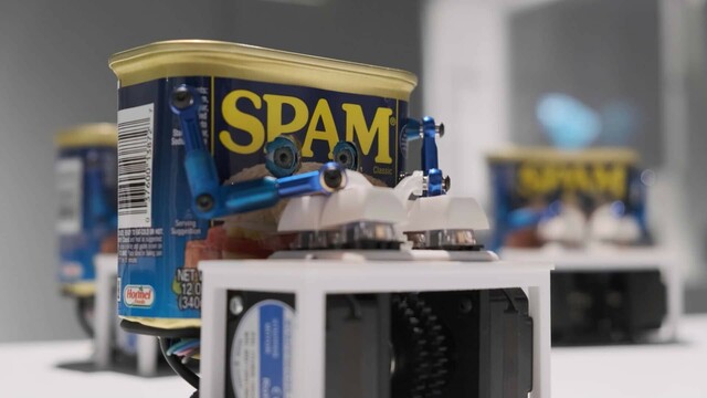 A can of SPAM with arms that press keys on a 4-key keyboard