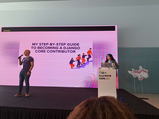 Woman presenting in front of a slide screen that says "My step by step guide to becoming a Django core contributor"