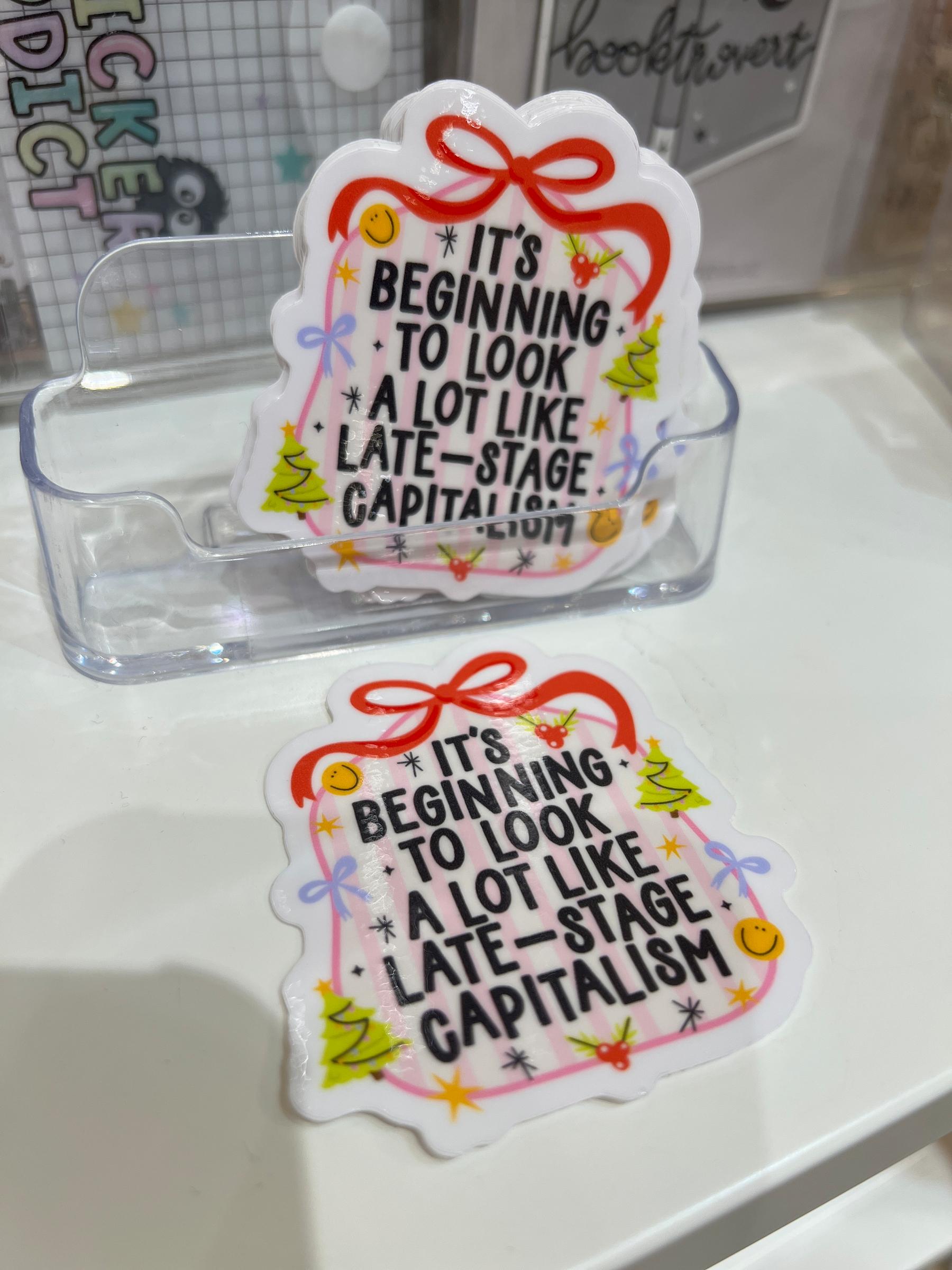 Stickers in a holiday theme that say “it’s beginning to look a lot like late-stage capitalism”