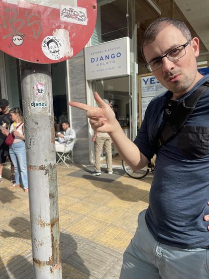 Thibaud pointing at a Django pony sticker in front of the Django gelato shop in Athens. 