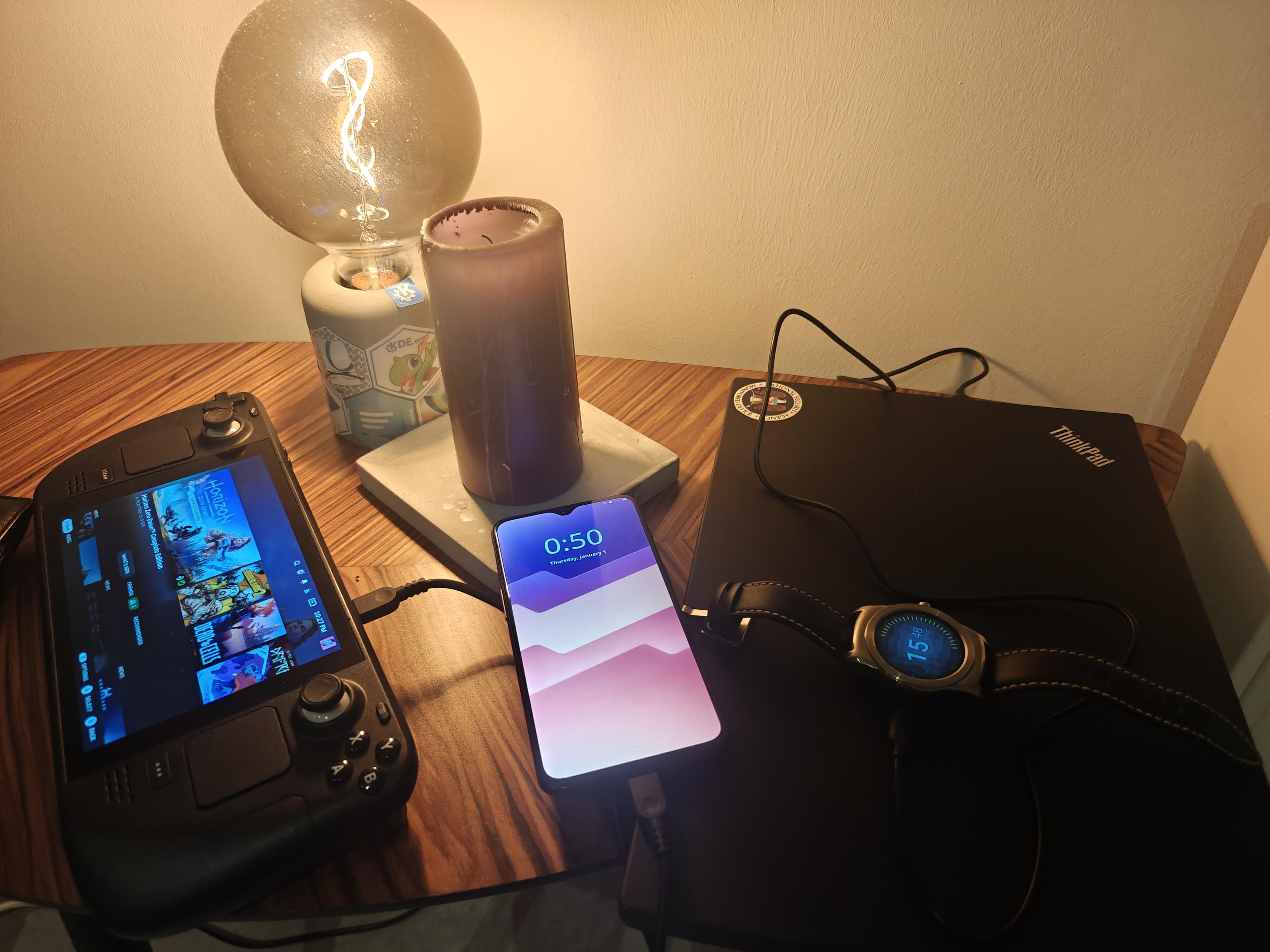 Picture of a closed laptop, a steam deck, a one plus 6t running plasma mobile and a watch running asteroid OS