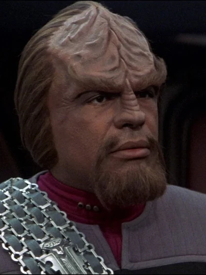 Worf as portrayed by Michael Dorn.

He is a black Klingon male with brown hair and dark eyes. He has the typical Klingon forehead ridges and wears a silver baldric over his Starfleet Uniform.