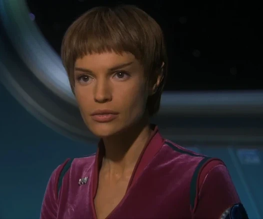 T'Pol as portrayed by Jolene Blalock. She is a Vulcan woman with pointed ears and the traditional Vulcan bowl cut.