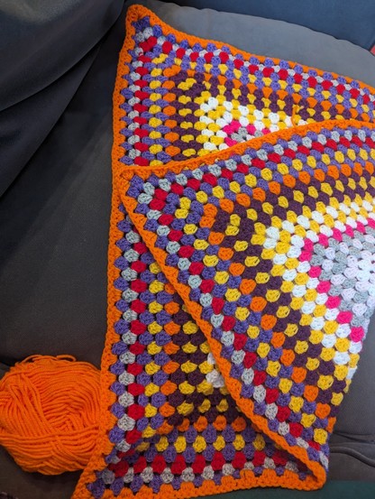 Multi coloured crochet blanket.