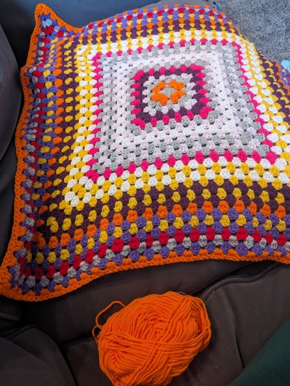 Multi coloured crochet blanket.