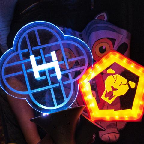 light sticks with Huntrix and Saja Boys logos etched into clear acrylic
