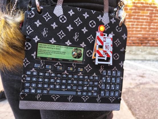 A Supercon badge cosplaying a designer bag