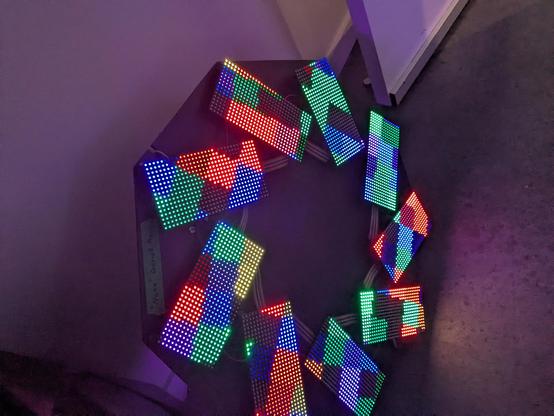 a ring with nine hub75 matrix LED panels, each rotated a bit. the pattern on the panels is aware of the rotation of each panel