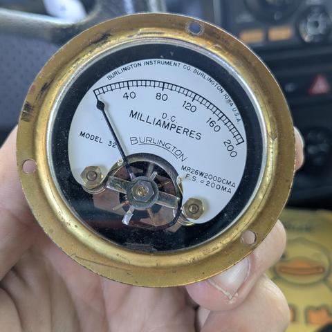 an analog galvanometer with a 200mA range and brass ring.