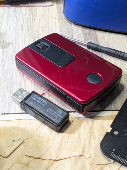 The Sony SMU-WM10 mouse in maroon and black, with radio receiver next to it