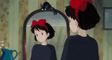 a girl with a red bow looks at herself in the mirror