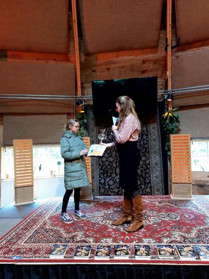 Anne-Goaitske Breteler giving a certificate and a massive trophy to a giant 10yo