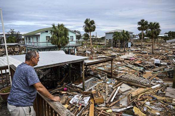 photo - resident surveying damage after Hurricane Helene