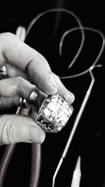 A hand holding a ring with tolls in the background
