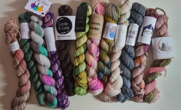12 skeins of handdyed yarn.  - colours range from creams to dark brown. variegated pinks, purples, greens, and greys.