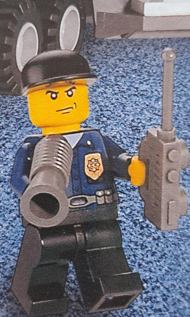 A #Lego police minifigure. The hubs of the two lorry wheels in the background look like bunny ears on his head. Well, to me, they do.