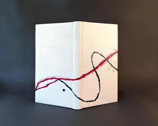 A white leather bound book standing upright. There are red and black painted lines flowing across the cover from front to back.