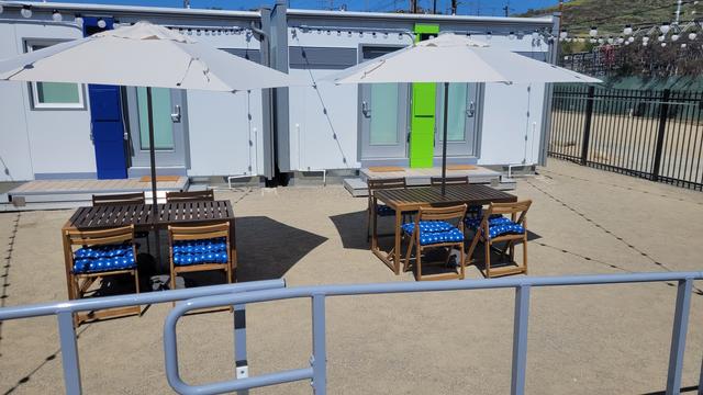 Metal shelter with doors and air conditioning, benches with umbrellas